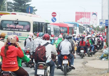 Ùn ứ giao thông tại cầu Kinh Xáng trên quốc lộ 1A (Châu Thành, Tiền Giang) và CSGT phải túc trực để điều tiết giao thông. Ảnh: T.PHÚC (Chụp lúc 14 giờ ngày 29-1)